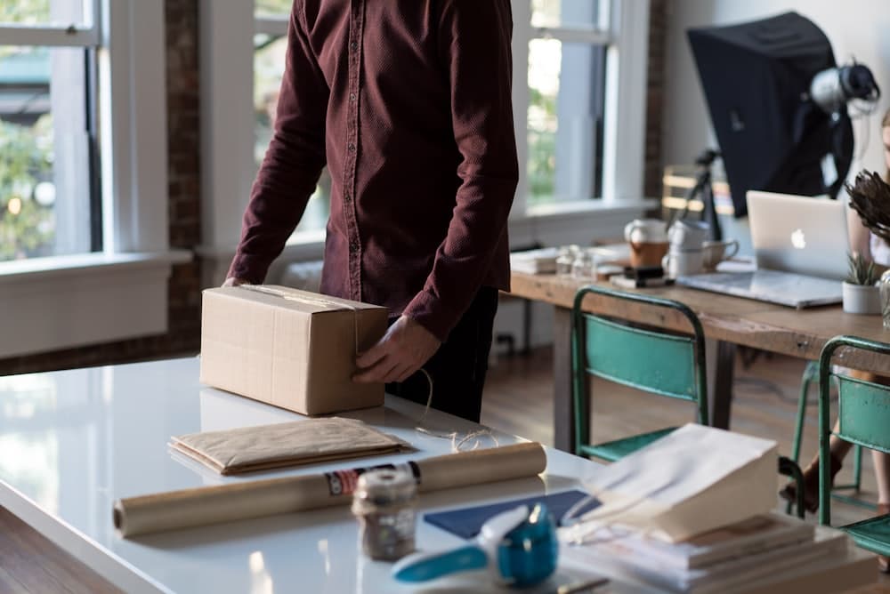 A seller packing a shipping box